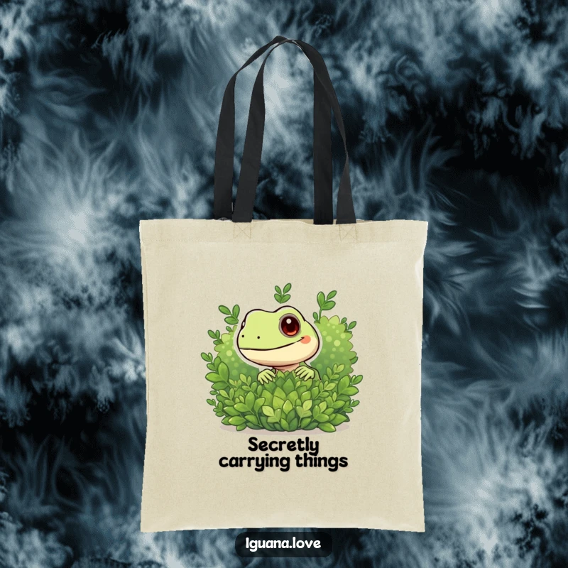 Funny tote bag with a playful iguana peeking from behind a green bush, a humorous and practical accessory.